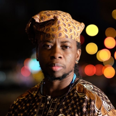 Seyi is a Nigerian gender non-conforming person wearing traditional Nigerian clothes.