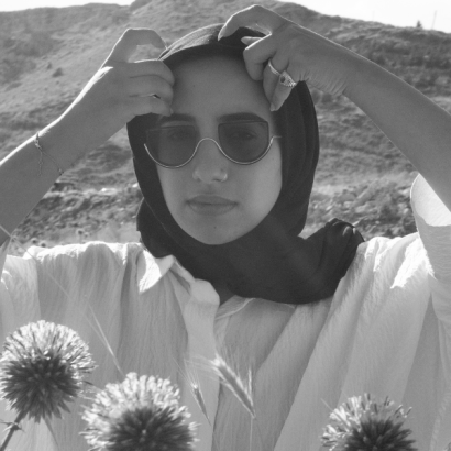 Jude is a Lebanese/American woman with a black hijab and black bottom-rimmed sunglasses.