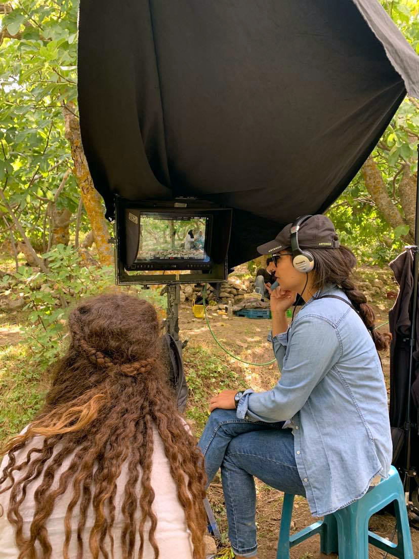 Erige, a Tunisian woman, watches her directors monitor while on set in Tunisia.