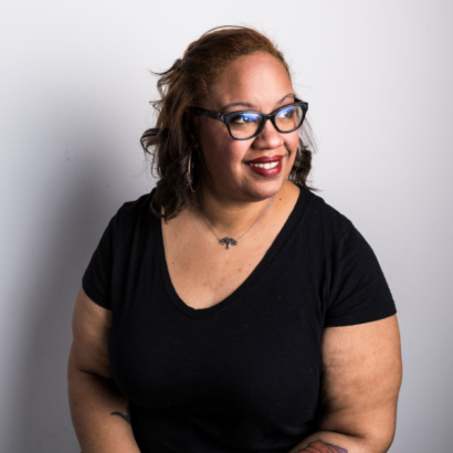Toni Cunningham is a Black woman with straight, brown, shoulder-length hair, black glasses and a black t-shirt.